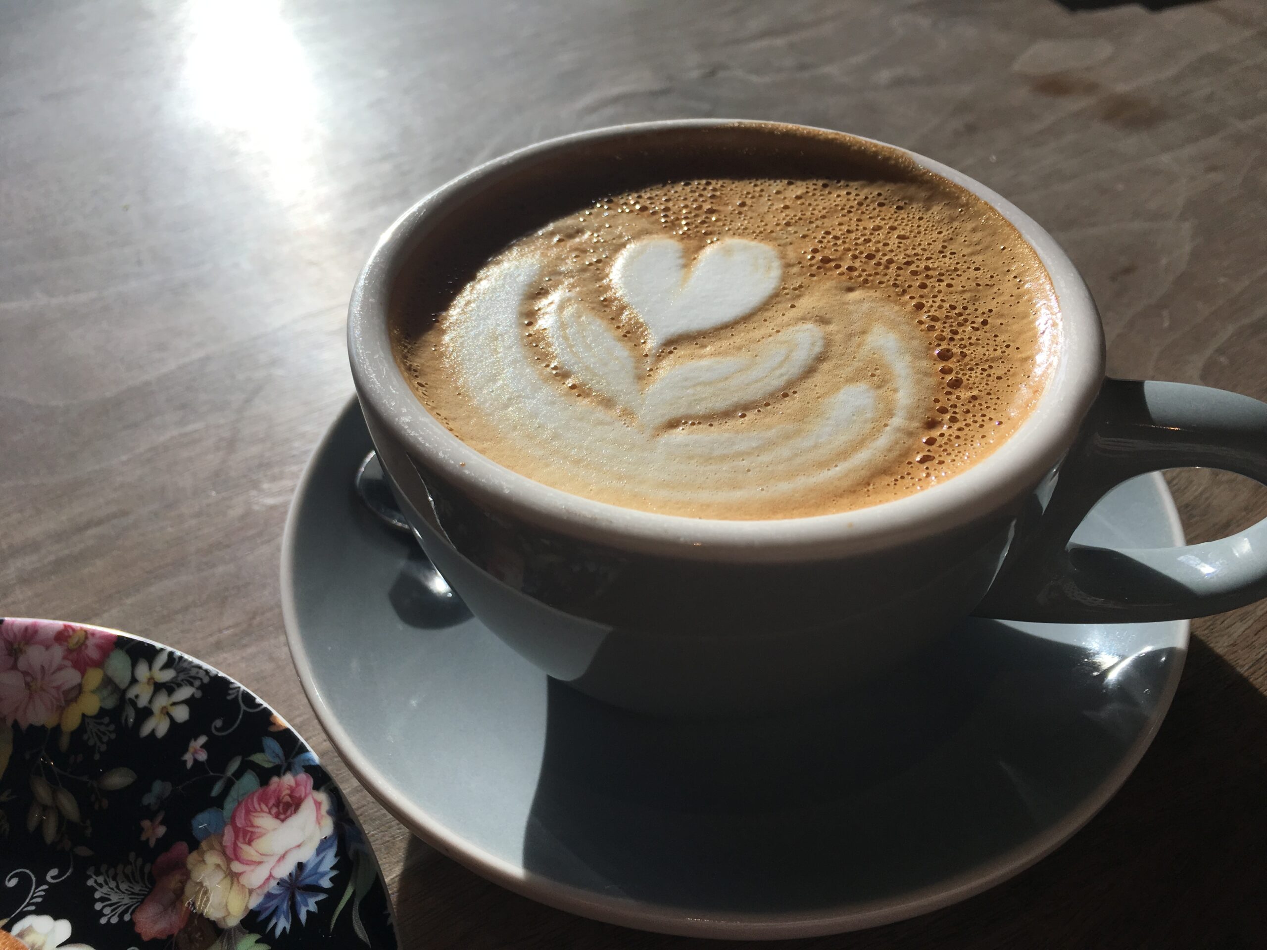 Coffee with a ray of light on a wooden table.